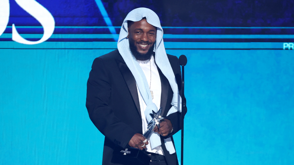 kendrick lamar holding bet award trophy on stage at 2025 bet awards