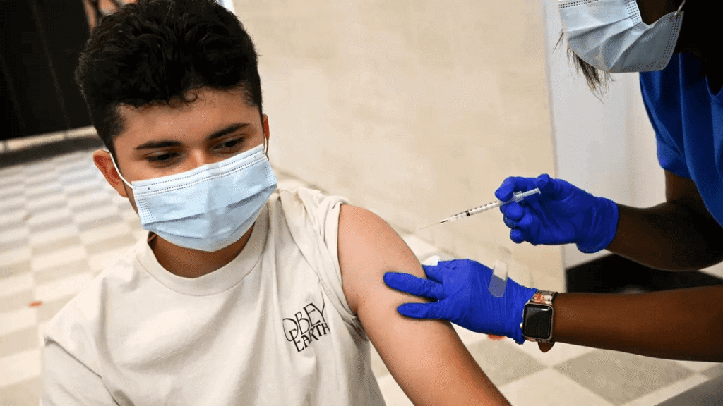 teen receiving covid vaccine injection in clinical setting